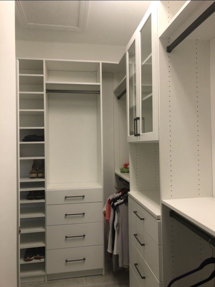 A walk in closet with lots of shelves and drawers