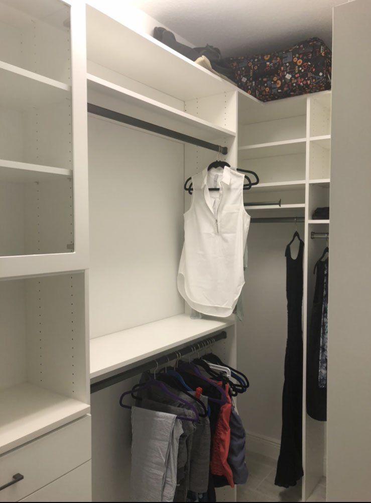 A walk in closet with clothes hanging on racks and shelves