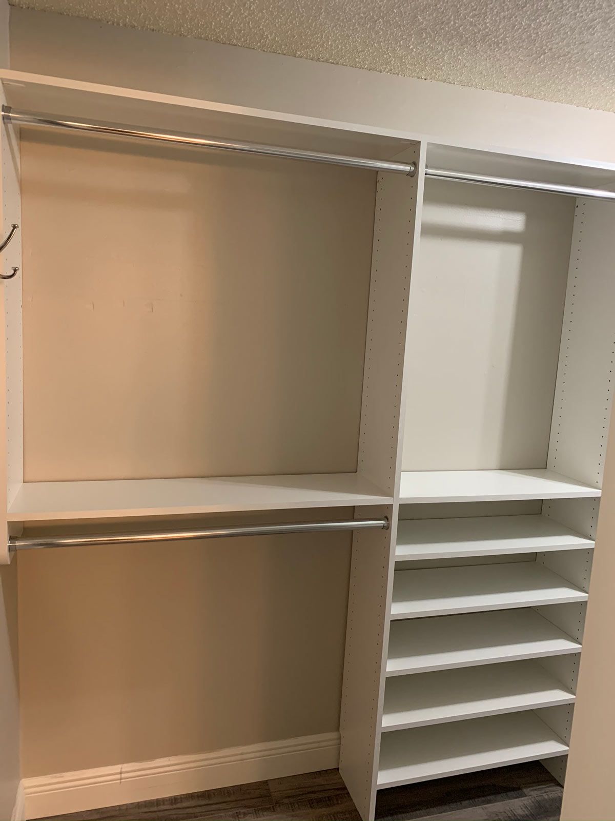 A walk in closet with lots of shelves and clothes racks.