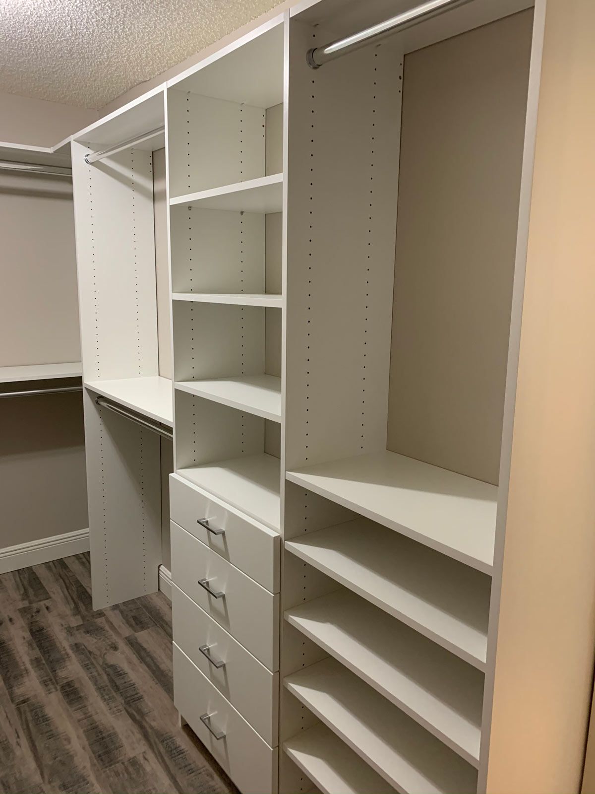 A walk in closet with lots of shelves and drawers