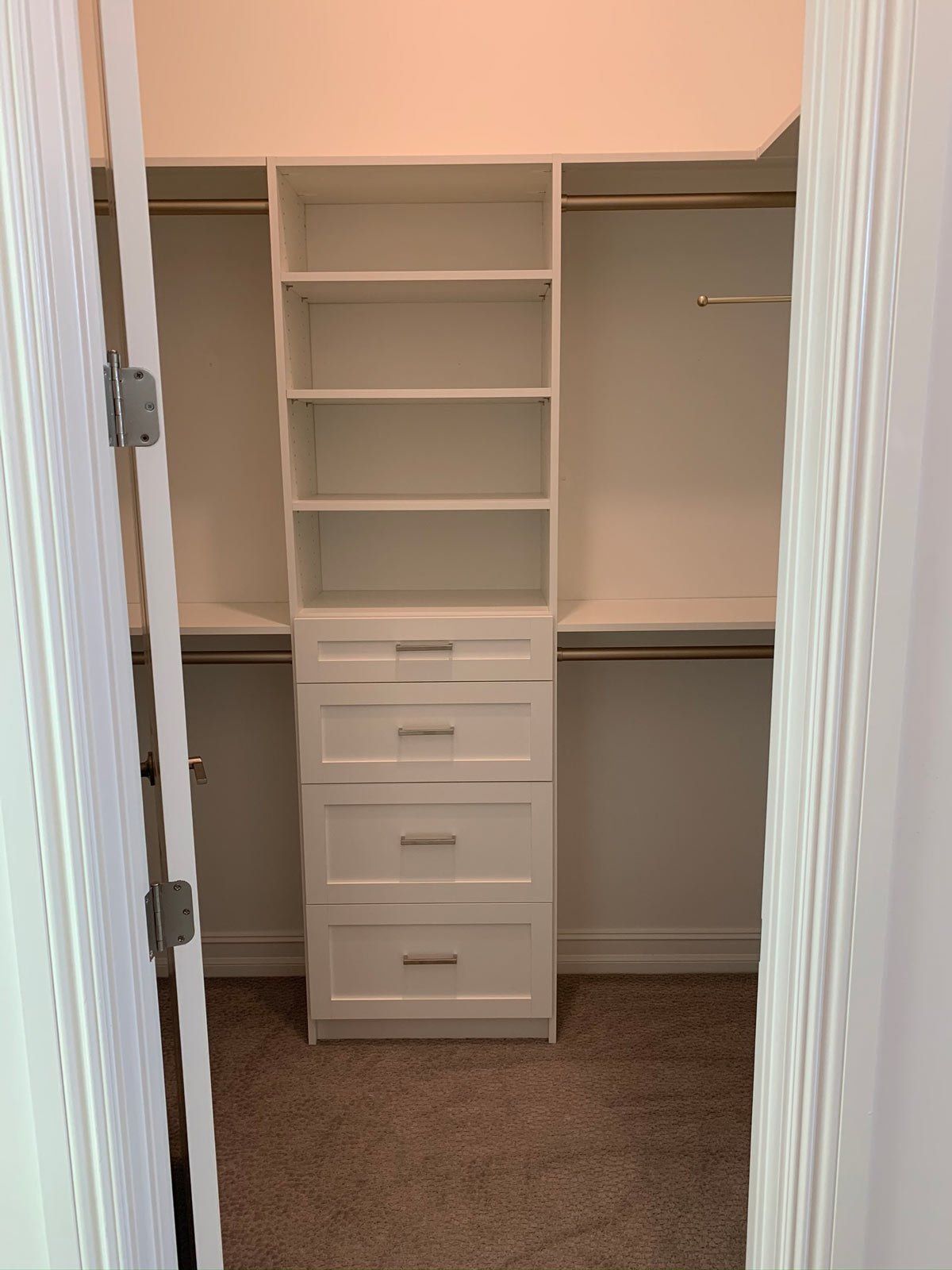 A walk in closet with lots of shelves and drawers.