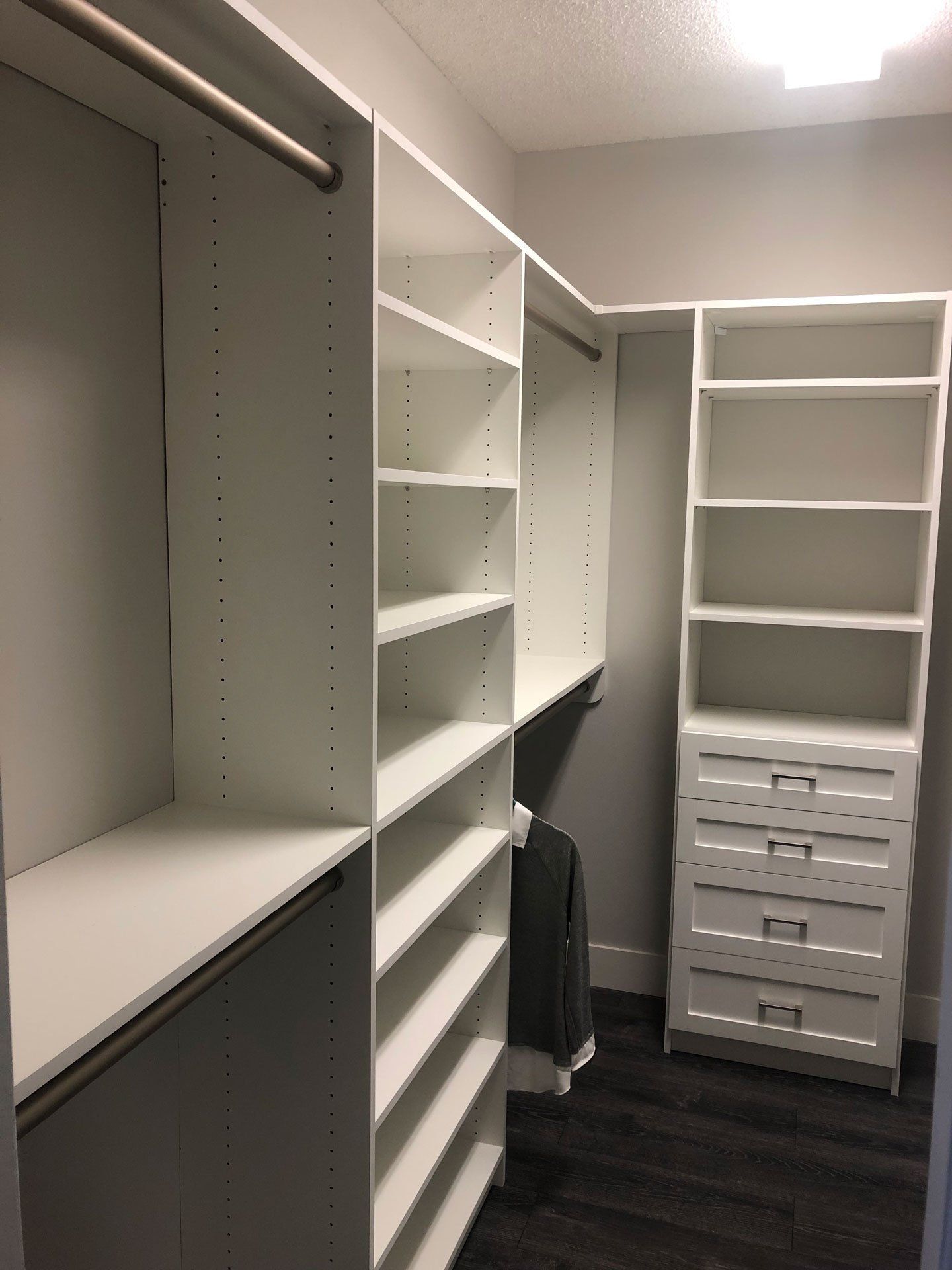 A walk in closet with lots of shelves and drawers