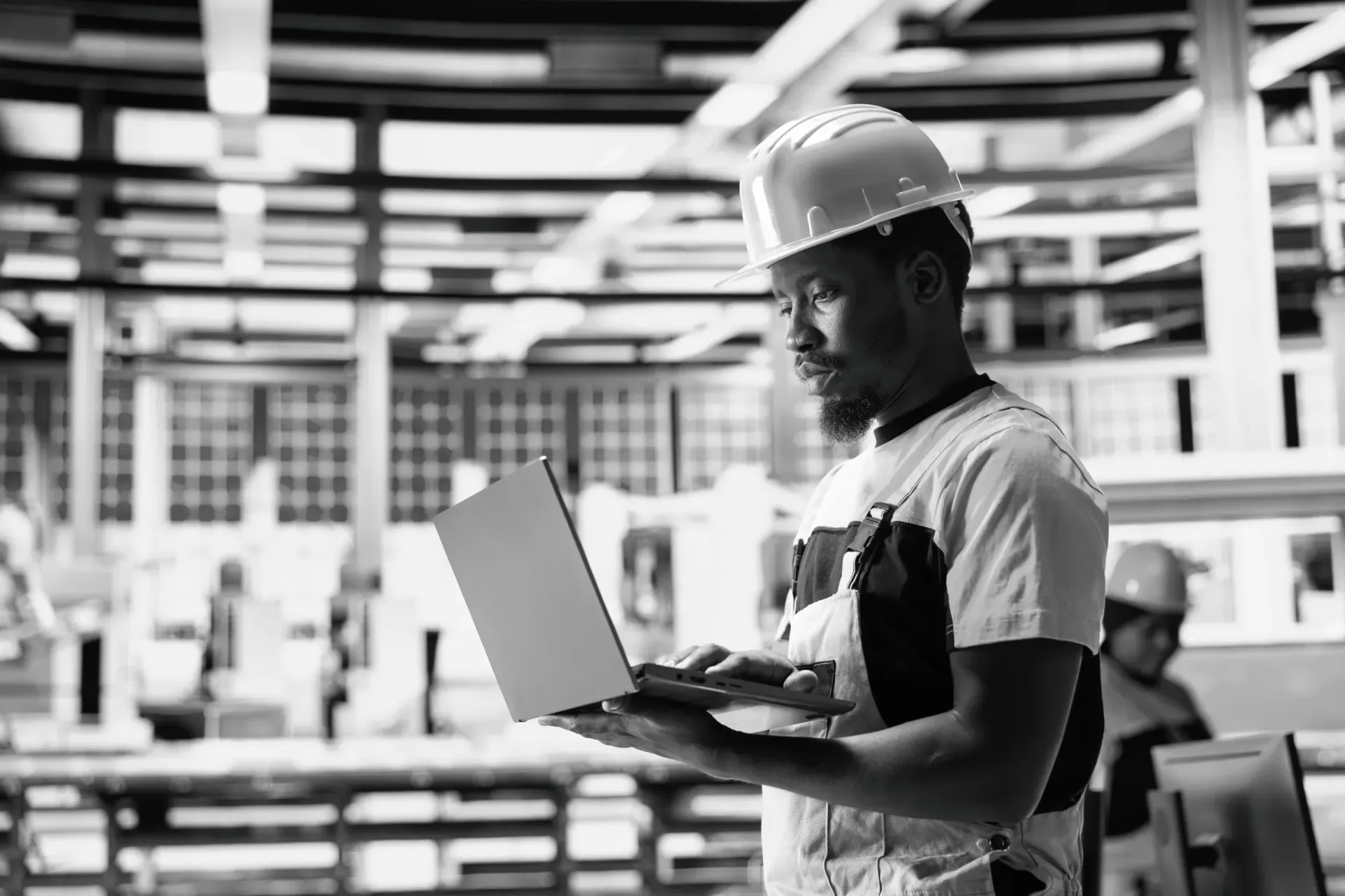 Man with hardhat ooking at a laptop