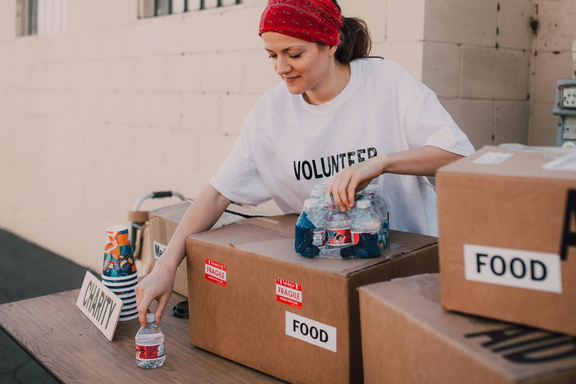 Volunteer sorts bottled water into a 