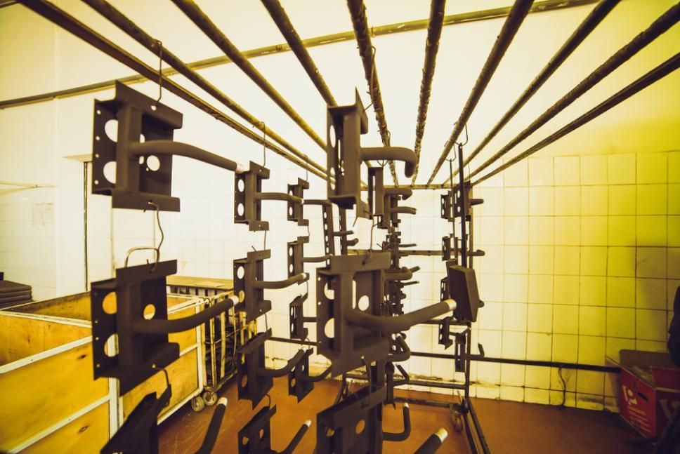 A Bunch of Metal Parts Are Hanging From the Ceiling in a Room — Alamo Powder Coaters in Mittagong, NSW