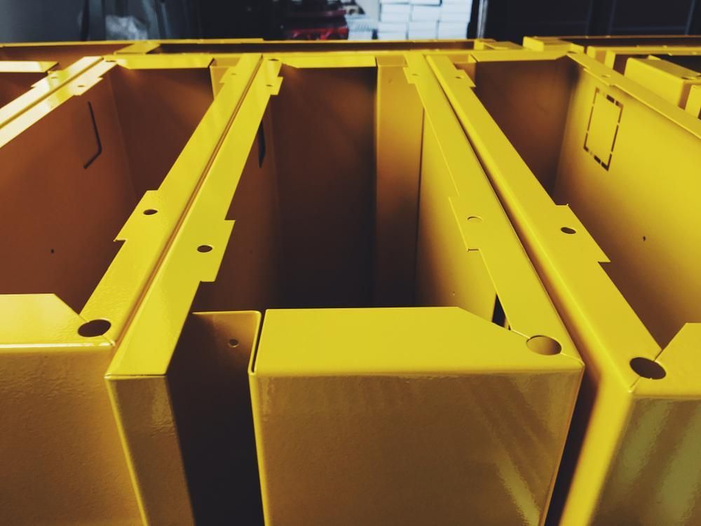 A Bunch of Yellow Boxes With Holes in Them — Alamo Powder Coaters in Heathcote, NSW
