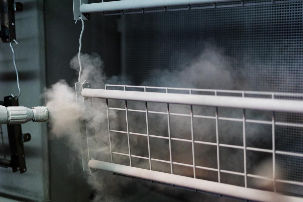 A Machine is Spraying Powder on a Metal Fence — Alamo Powder Coaters in Moss Vale, NSW