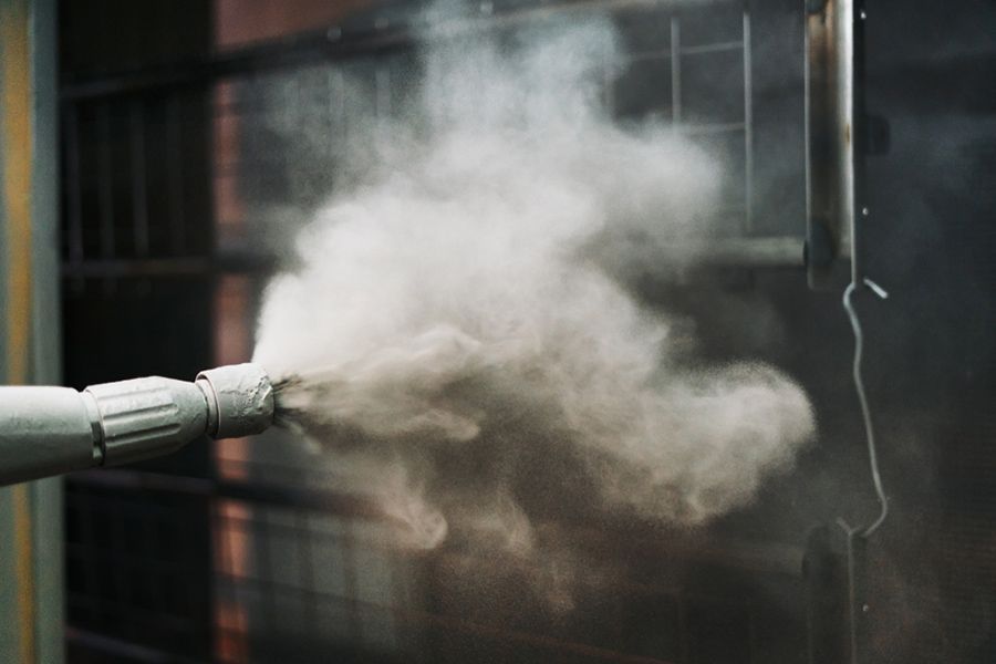 A Machine Is Spraying Powder on A Metal Surface — Alamo Powder Coaters in Unanderra, NSW