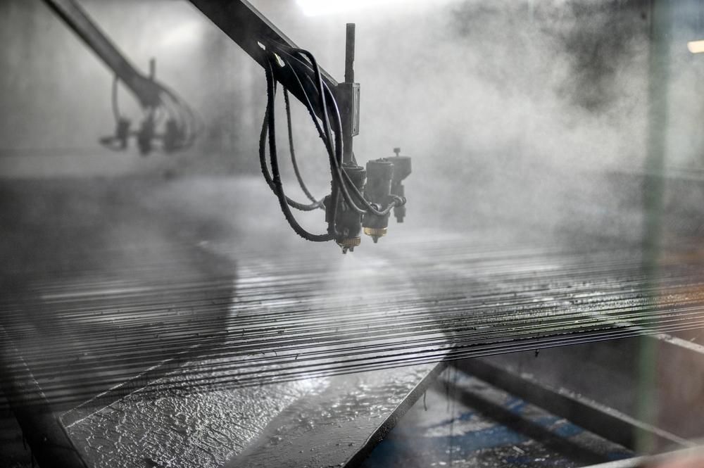 A Machine is Spraying Water on a Metal Surface in a Factory — Alamo Powder Coaters in Moss Vale, NSW