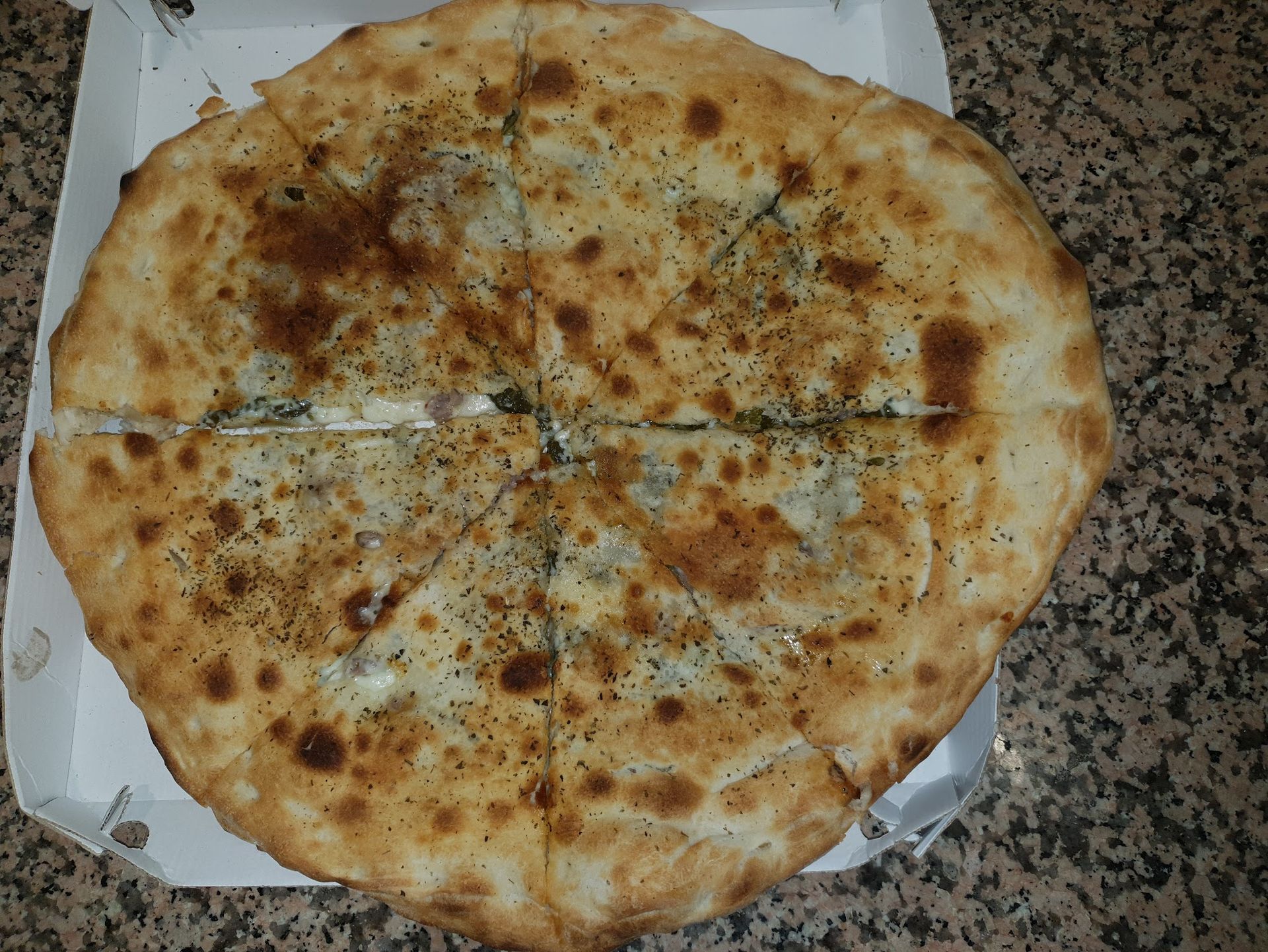 Una pizza è seduta in una scatola di cartone su un tavolo