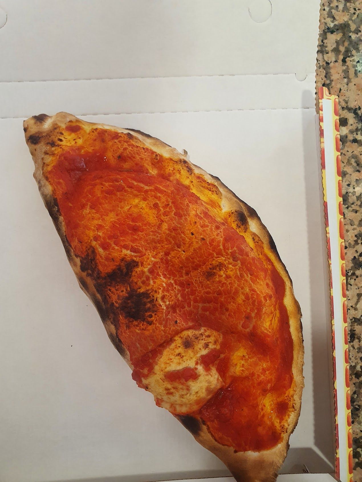 Una fetta di pizza è in una scatola sul bancone