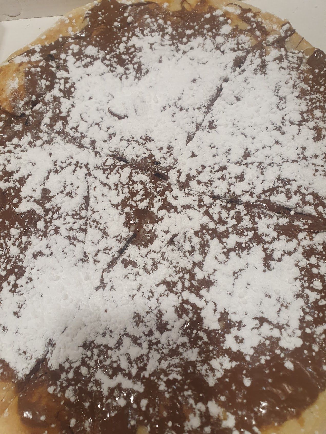 Una pizza con nutella e zucchero a velo sopra