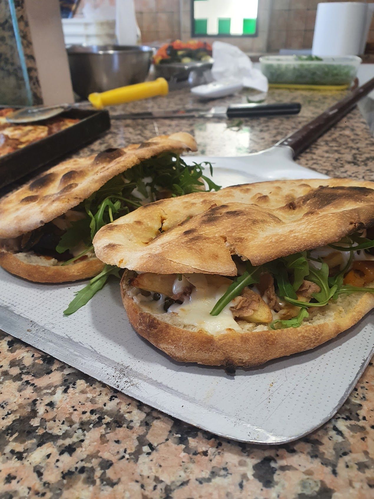 Due panini sono seduti su un vassoio sul bancone.