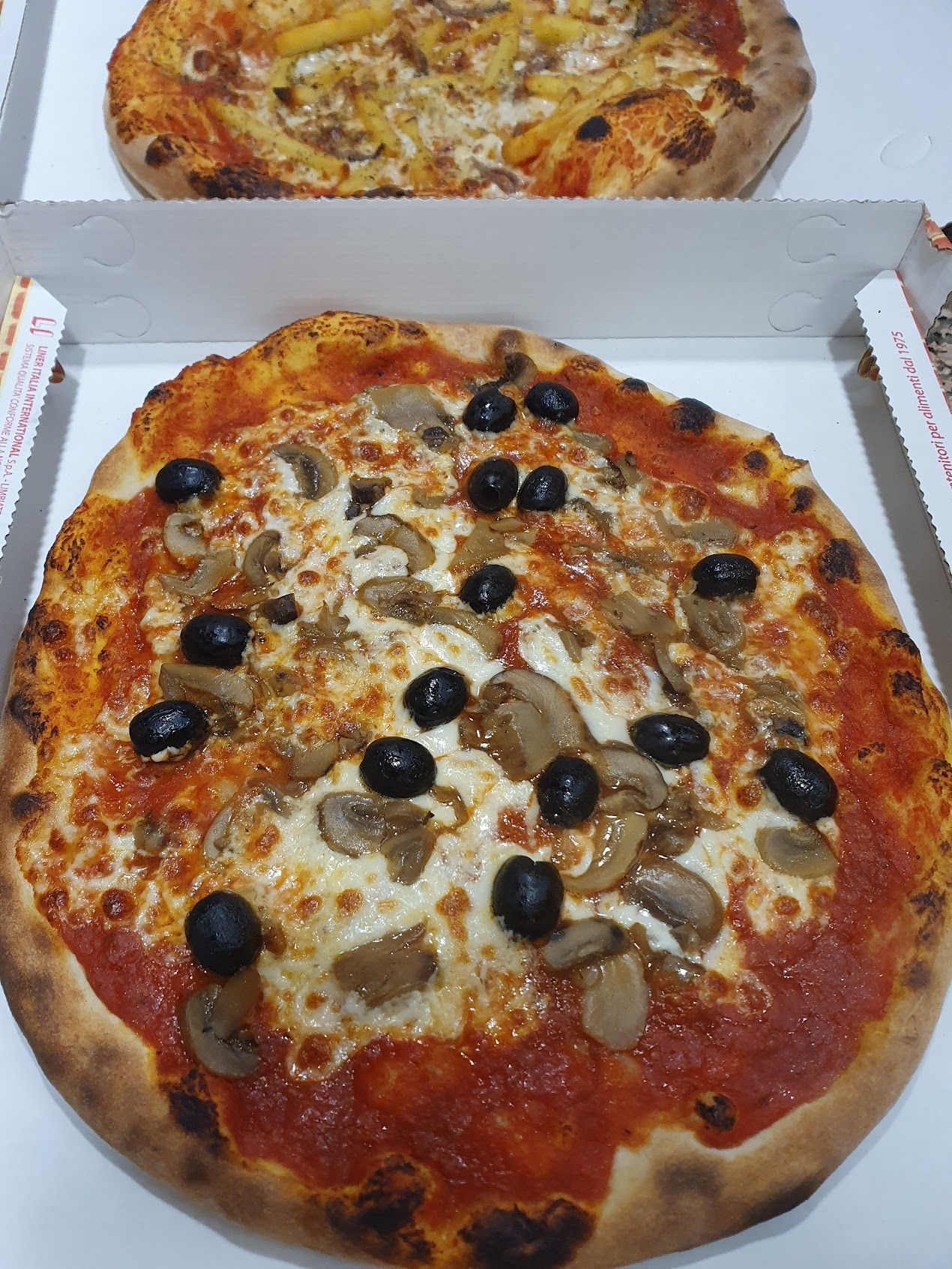 In una scatola c'è una pizza con funghi e olive