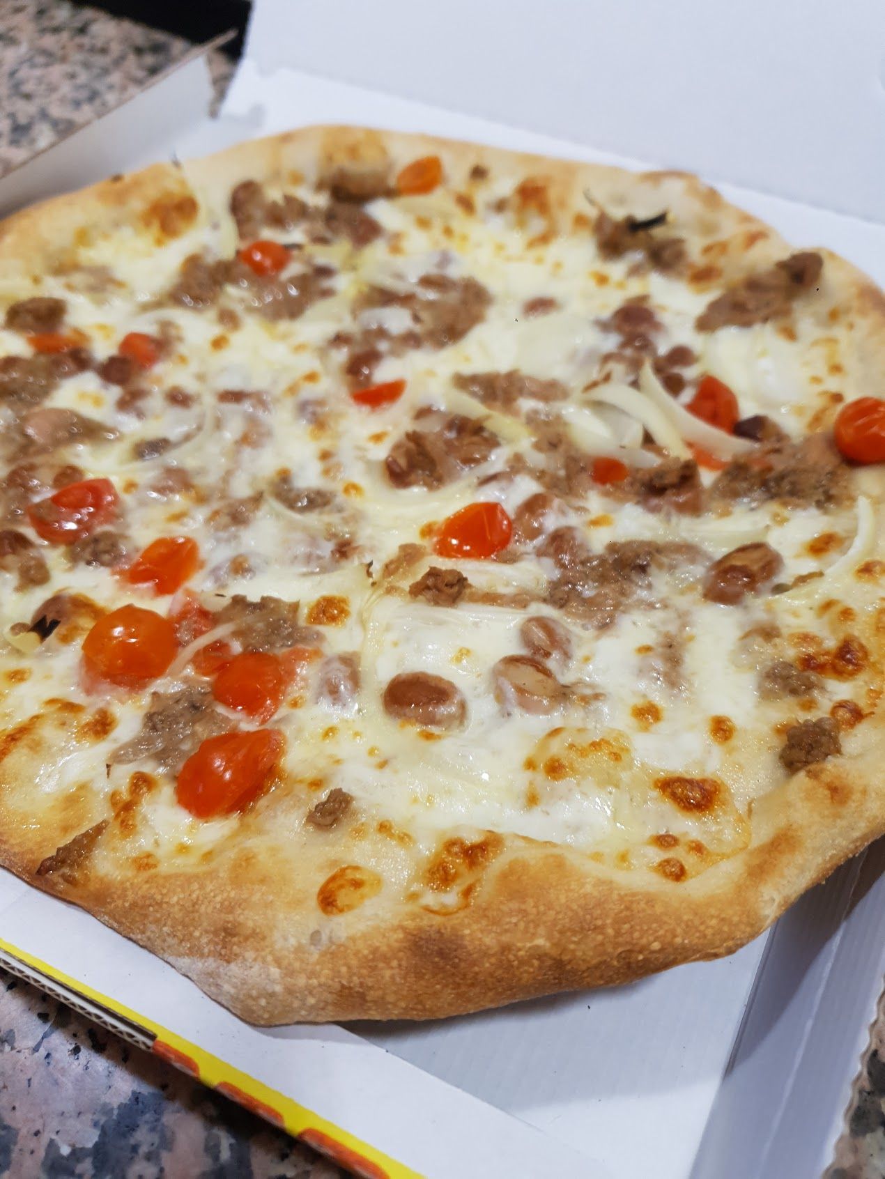 Una pizza è seduta in una scatola su un tavolo.