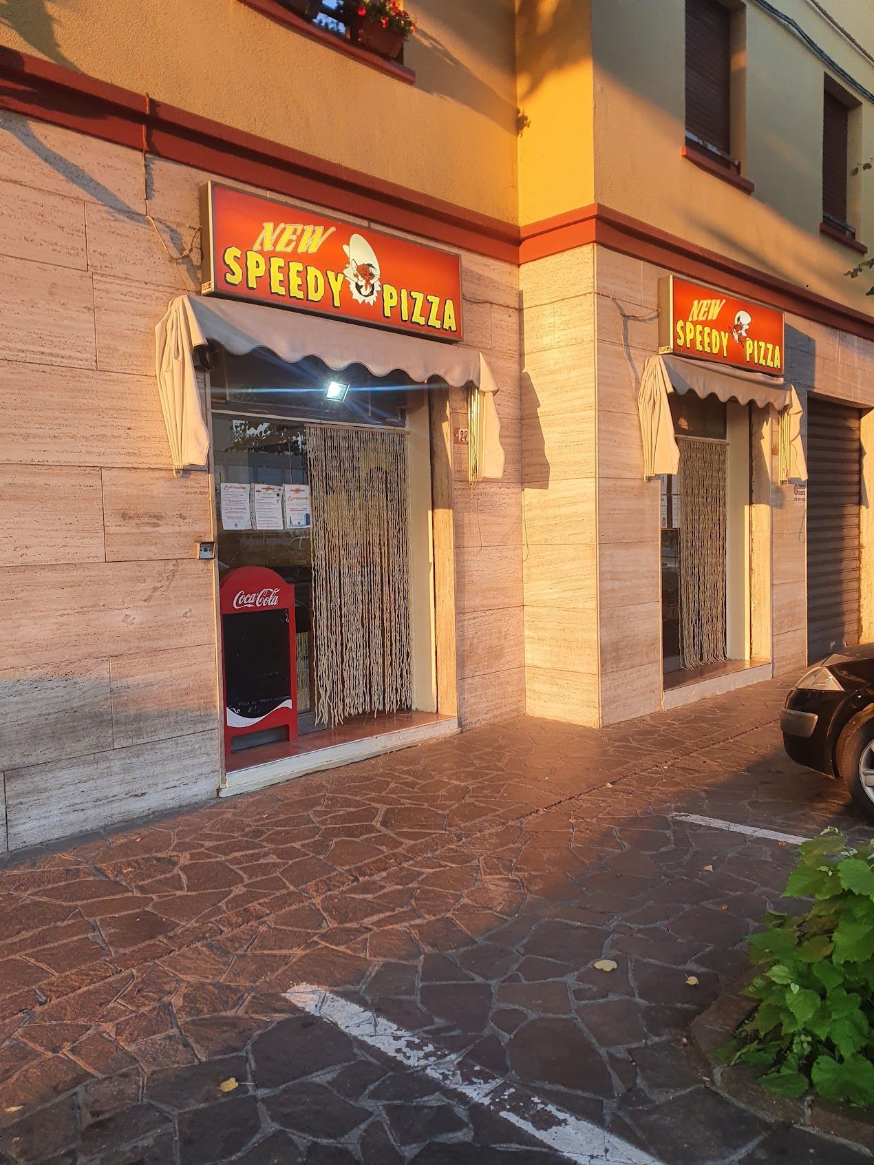 Un edificio con un cartello che dice nuova pizza veloce