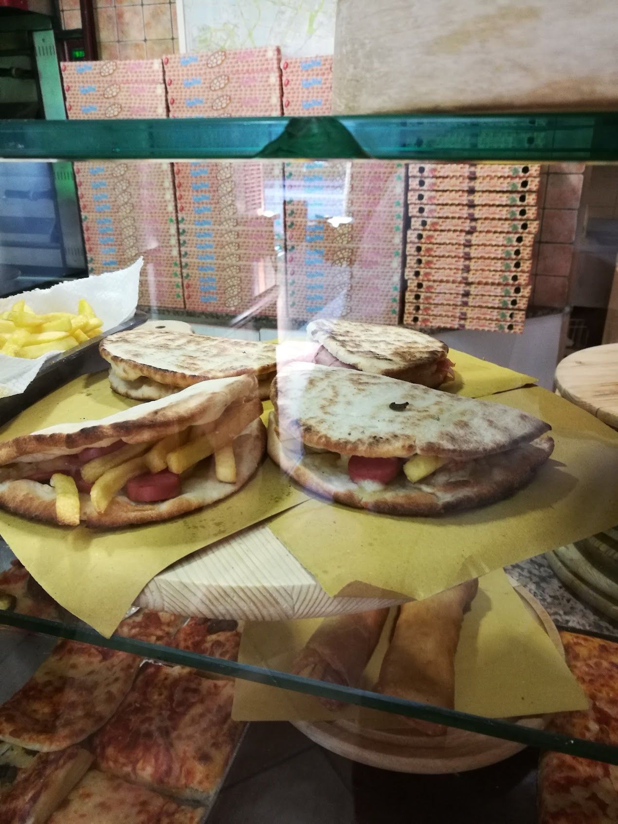 Una vetrina piena di pizze e panini