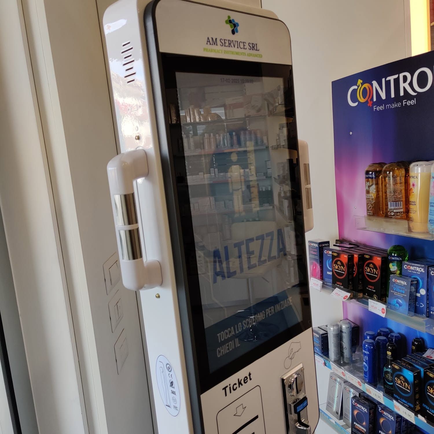 Frigorifero per birra con sportello in vetro accanto a un espositore per snack, con bottiglie visibili all'interno e la scritta