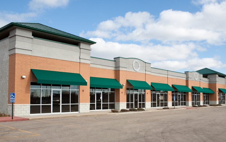 A brick building with green awnings on the windows