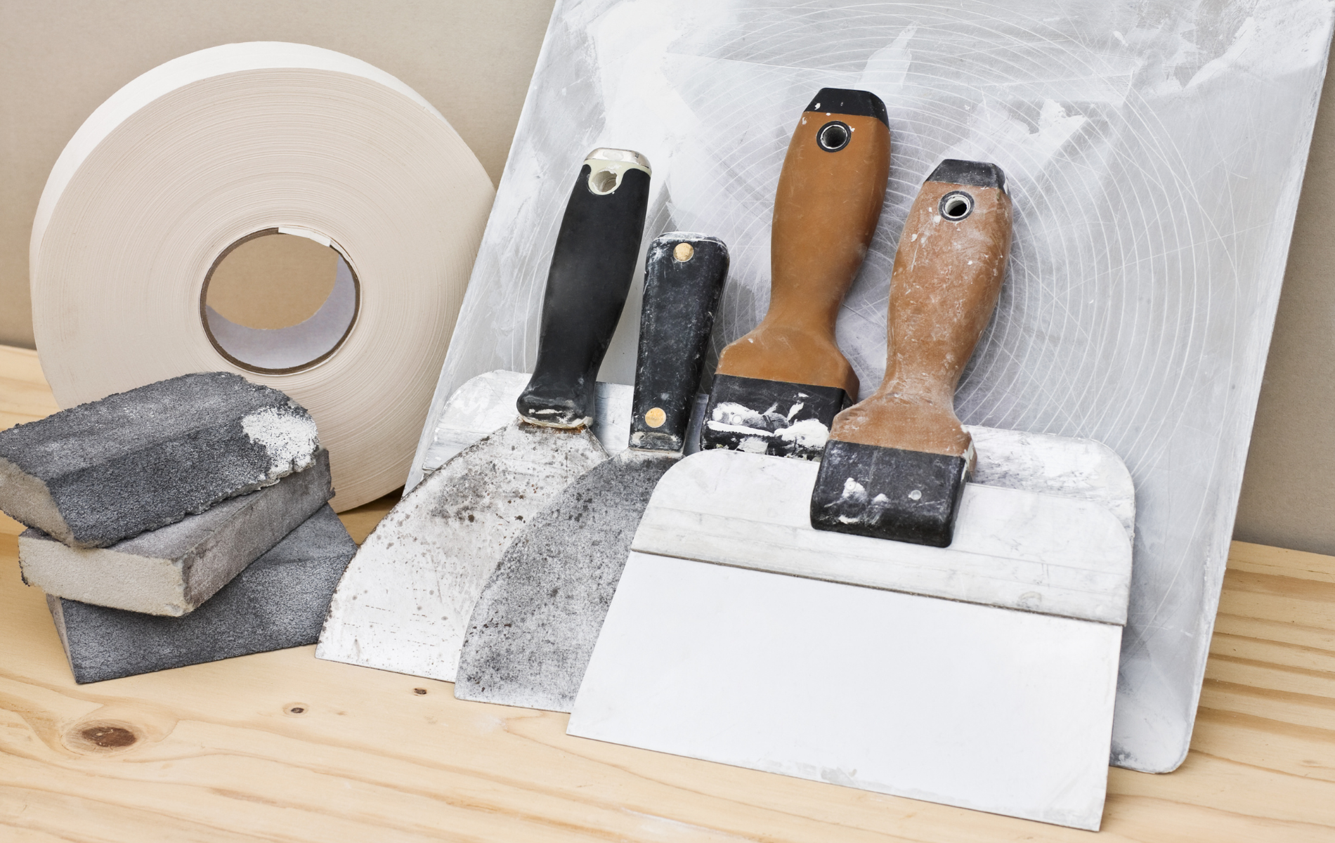 A wooden table topped with tools and tape.