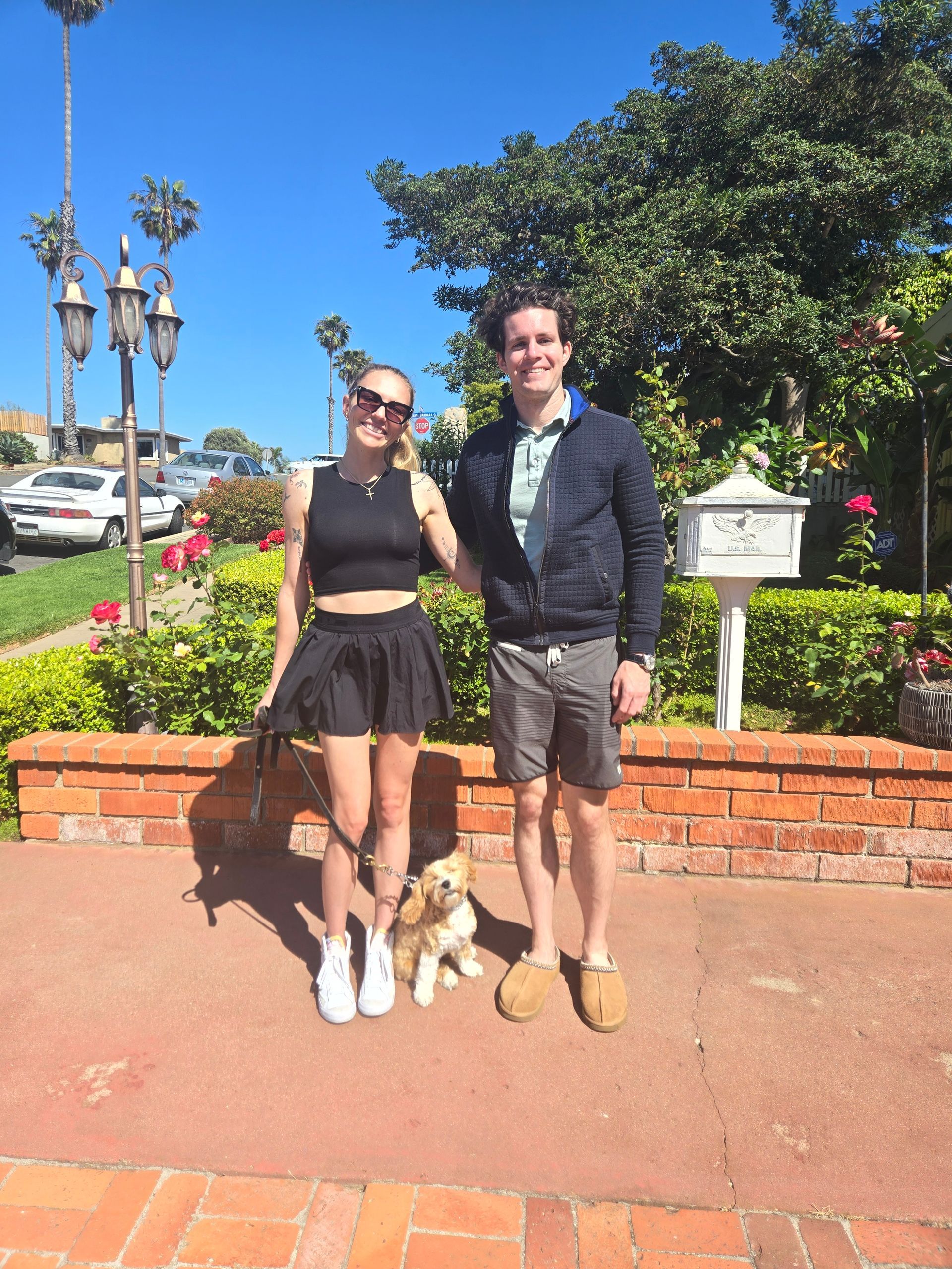 A man and a woman are posing for a picture with their dog.