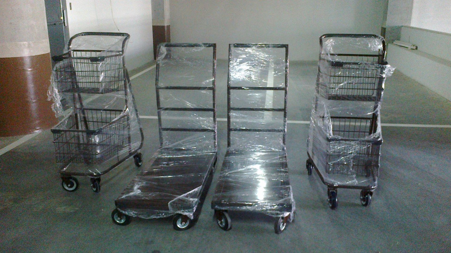 Tres carritos de compra envueltos en plástico en un garaje