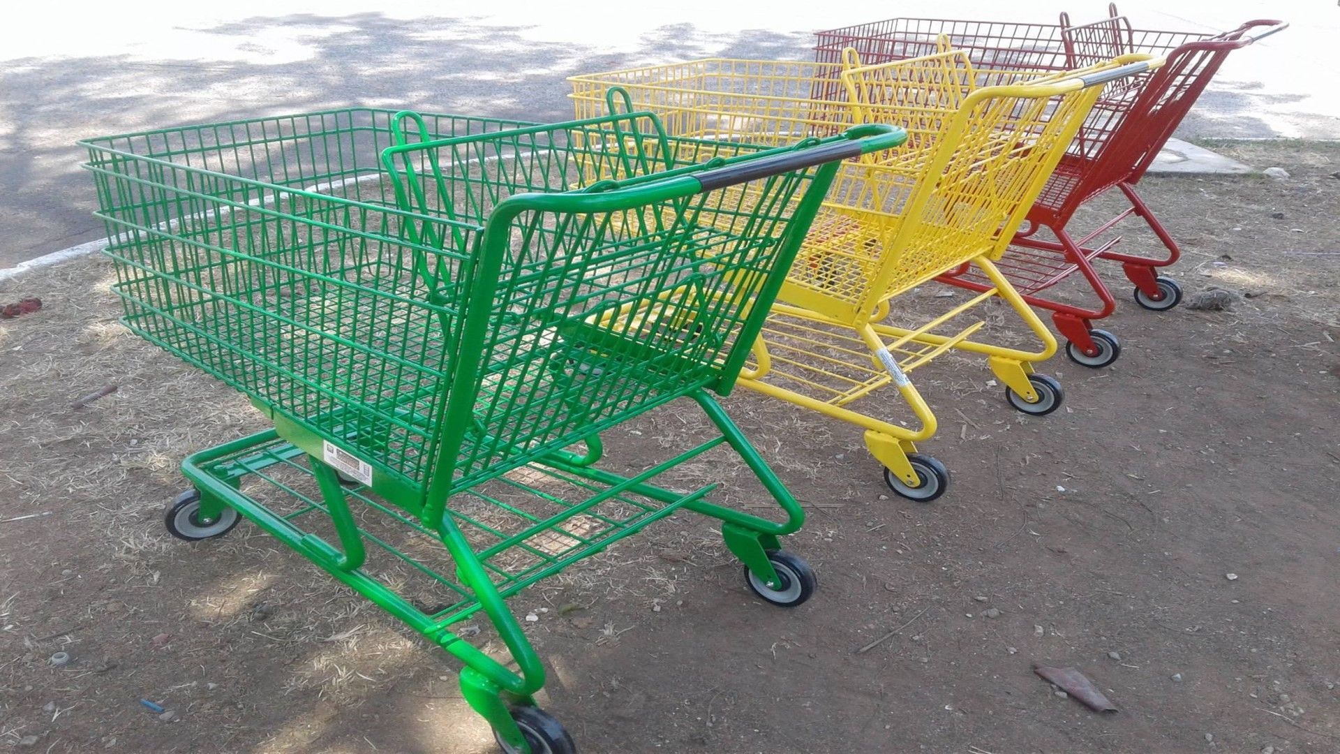 Una fila de carritos de compra están alineados en el suelo.