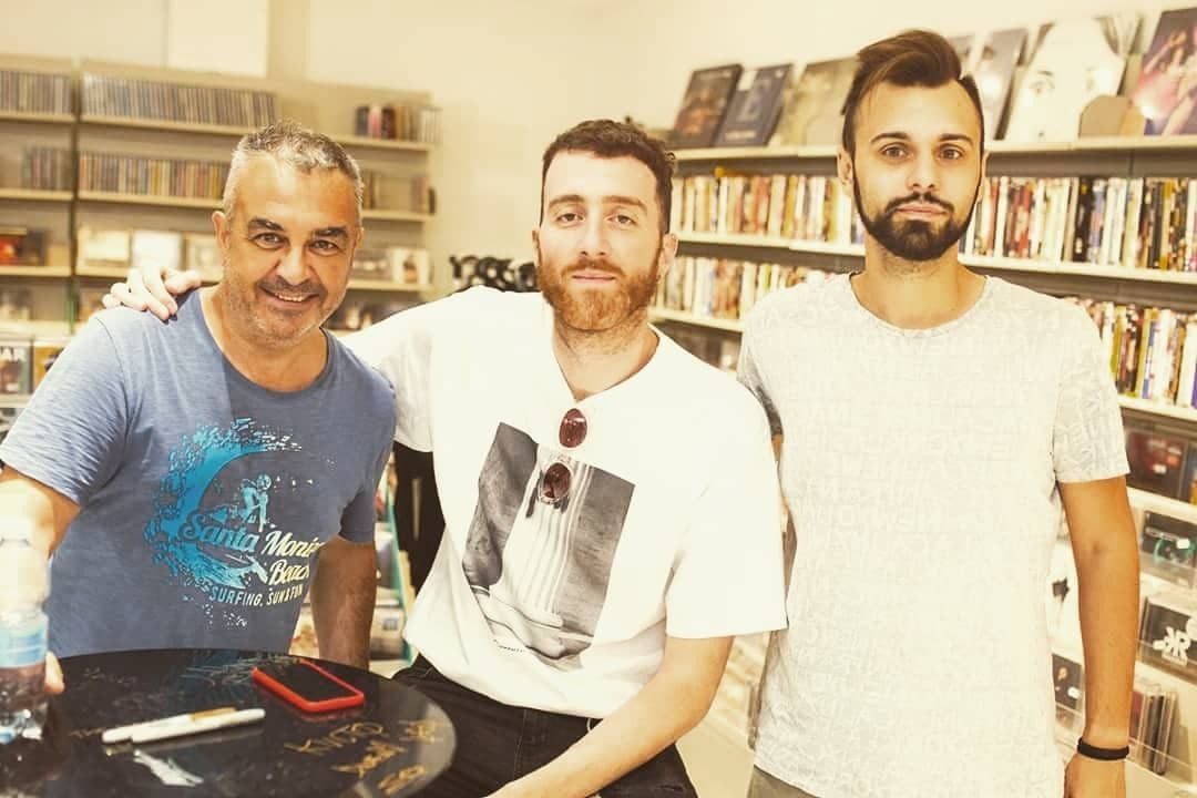 Tre uomini posano per una foto in una biblioteca
