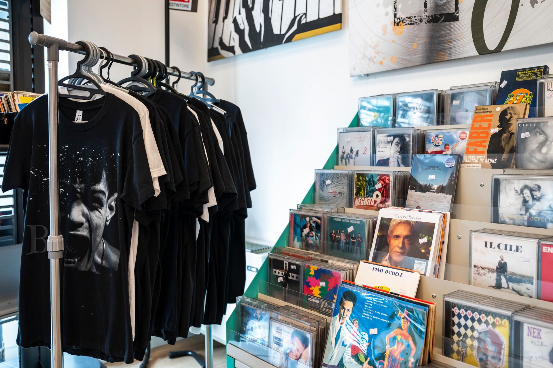 Una fila di magliette nere sono appese su uno scaffale in un negozio.