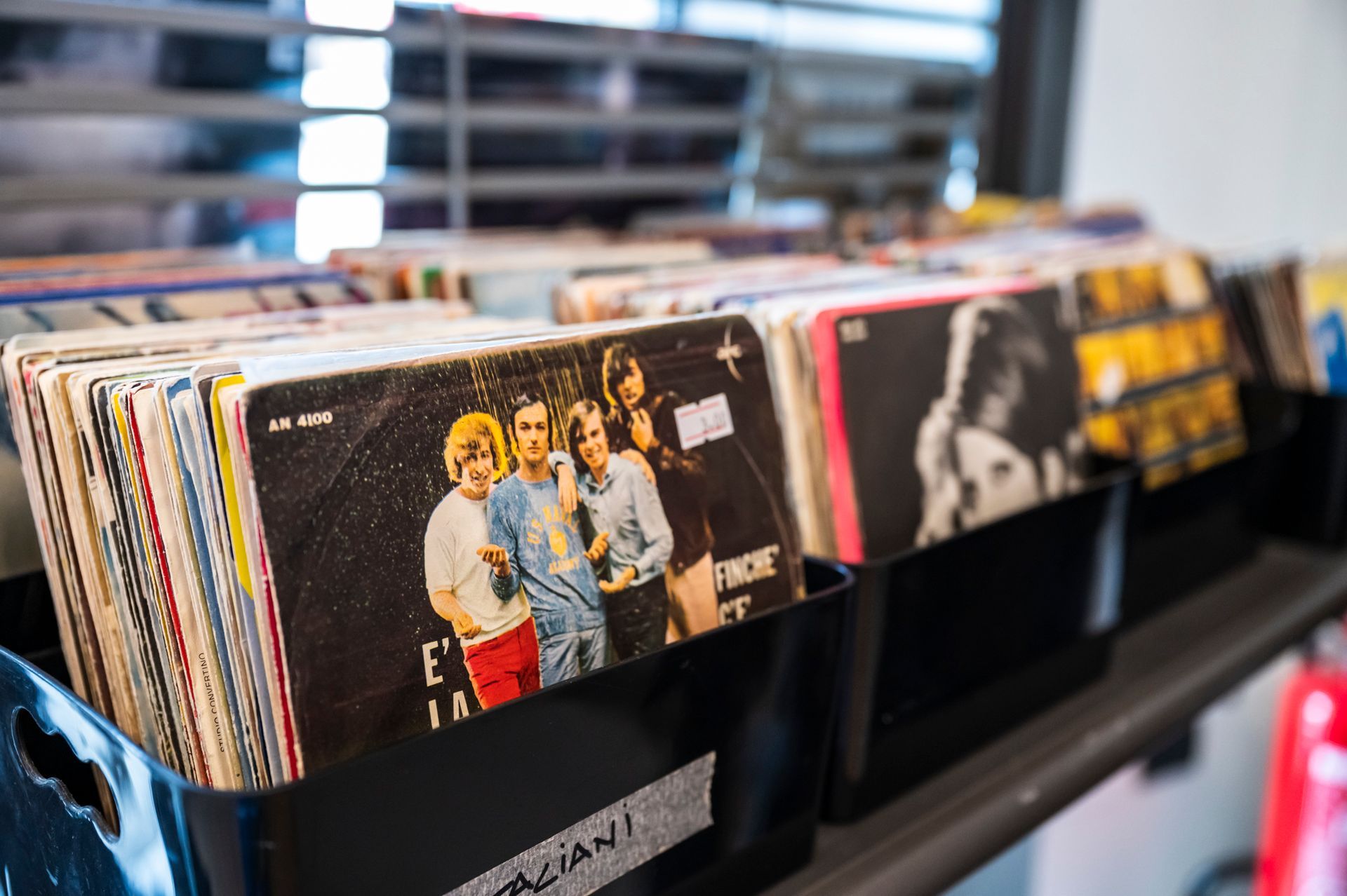 Un mucchio di dischi sono fermi sullo scaffale di un negozio.