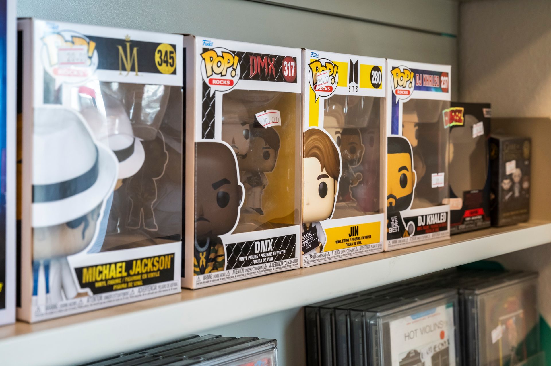 Una fila di personaggi funko pop sono allineati su uno scaffale.