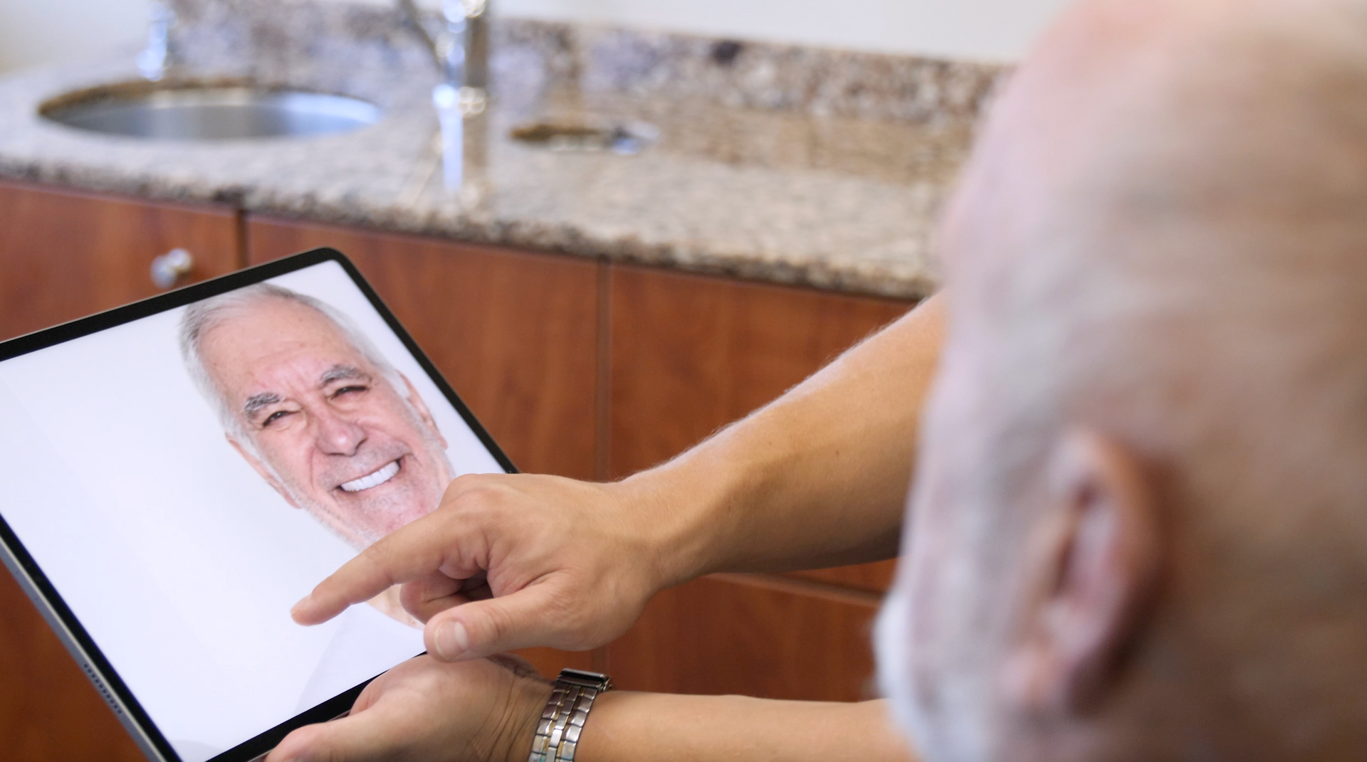man looking at his teeth on a mirror