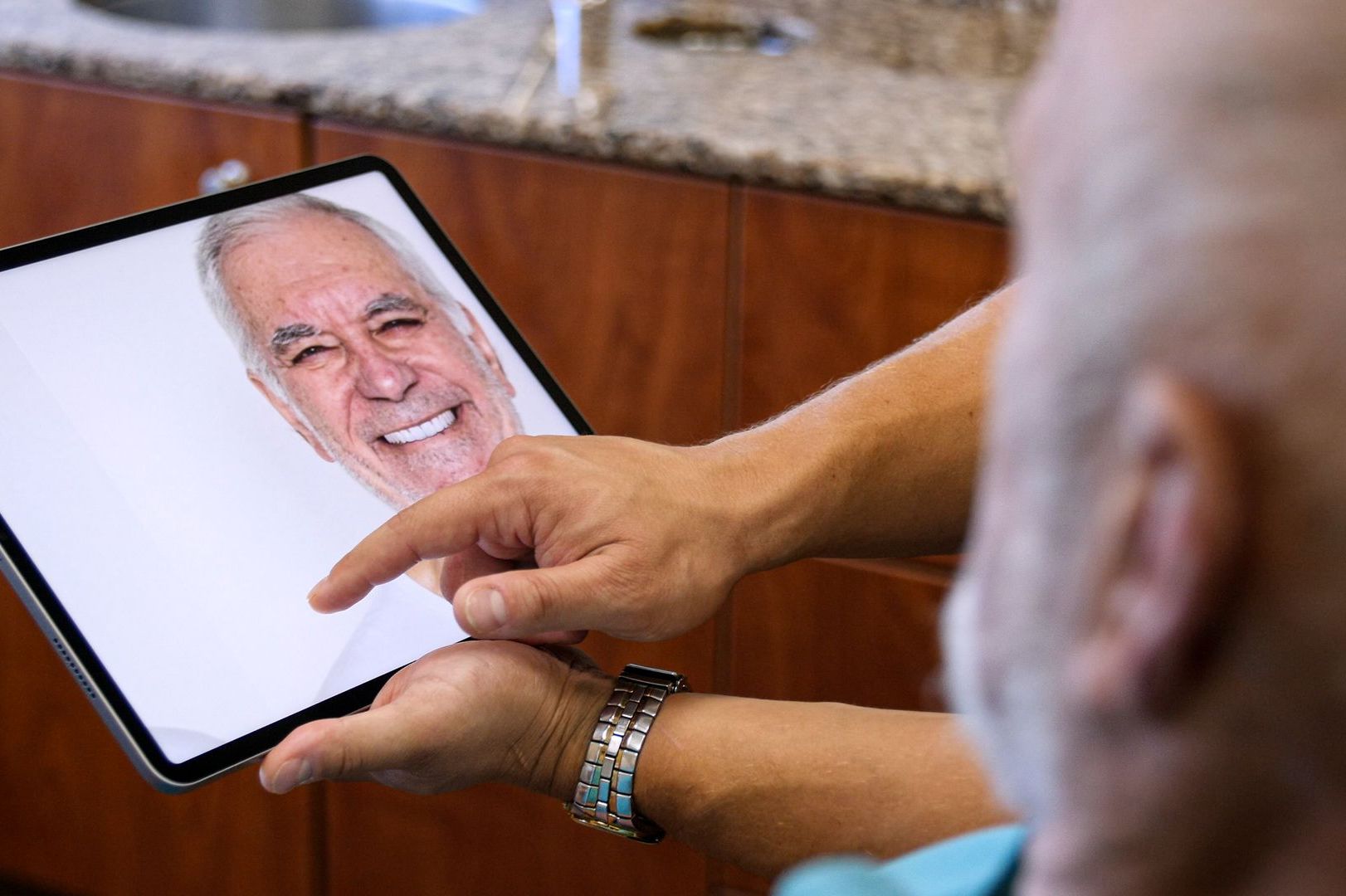 smiling man on iPad | Cosmetic dentist in Monroe and Highland Park NJ