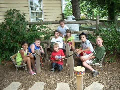 A group of children are posing for a picture in front of a house