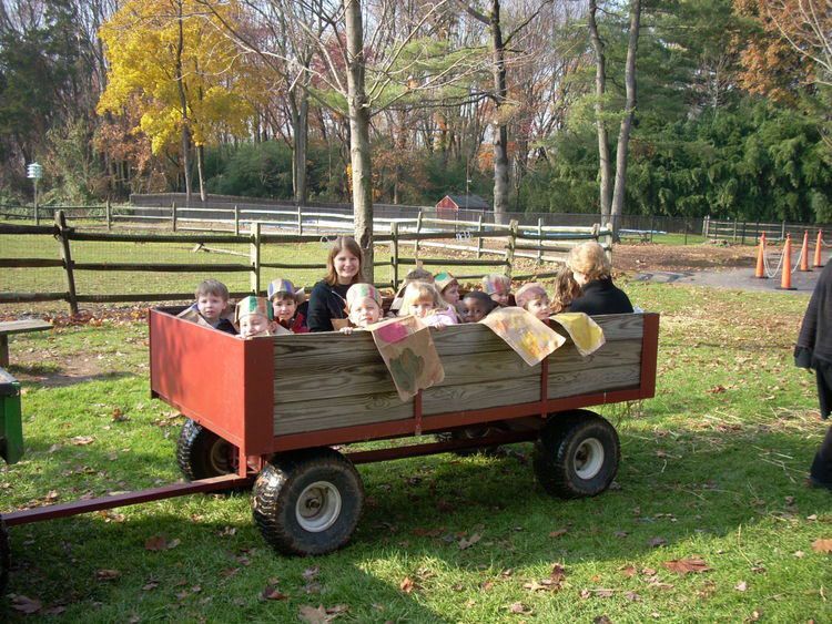 A group of children are riding in a wooden wagon
