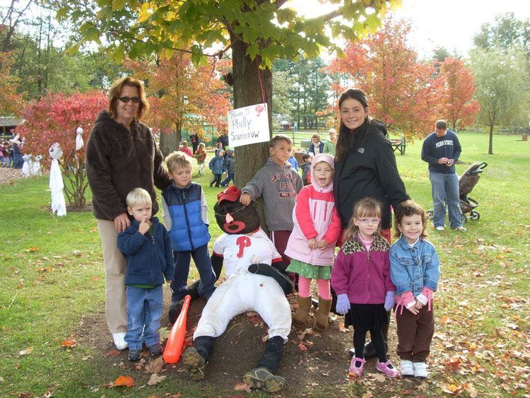 A group of children are posing for a picture with a baseball player with the letter p on his uniform