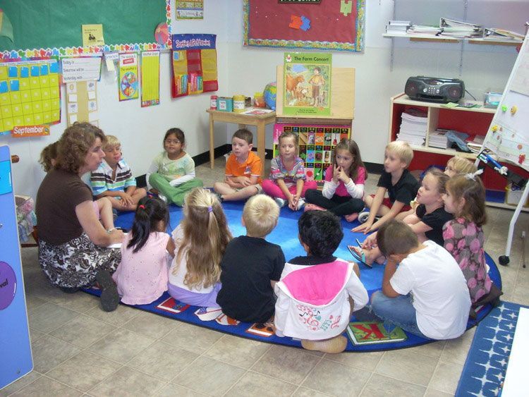 A group of children are sitting in a circle in a classroom