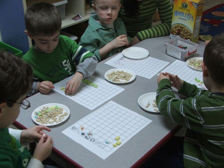 A box of apollo cereal sits on a table with children