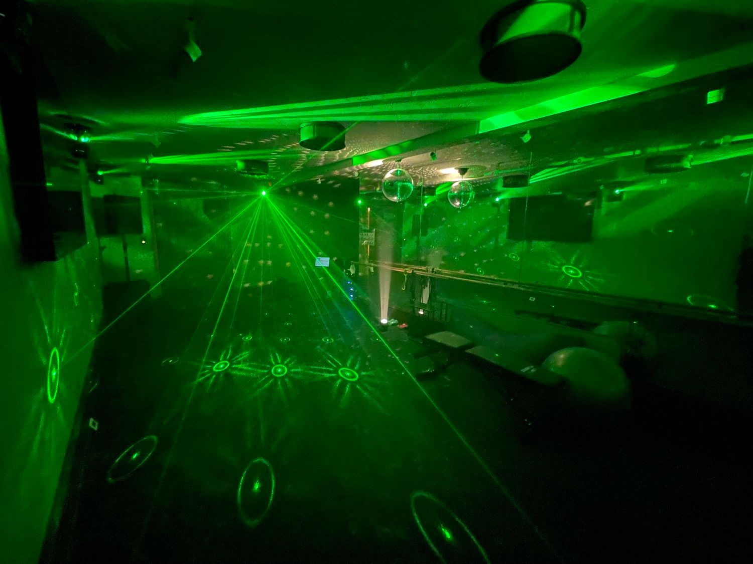 A room filled with green lights and a disco ball.
