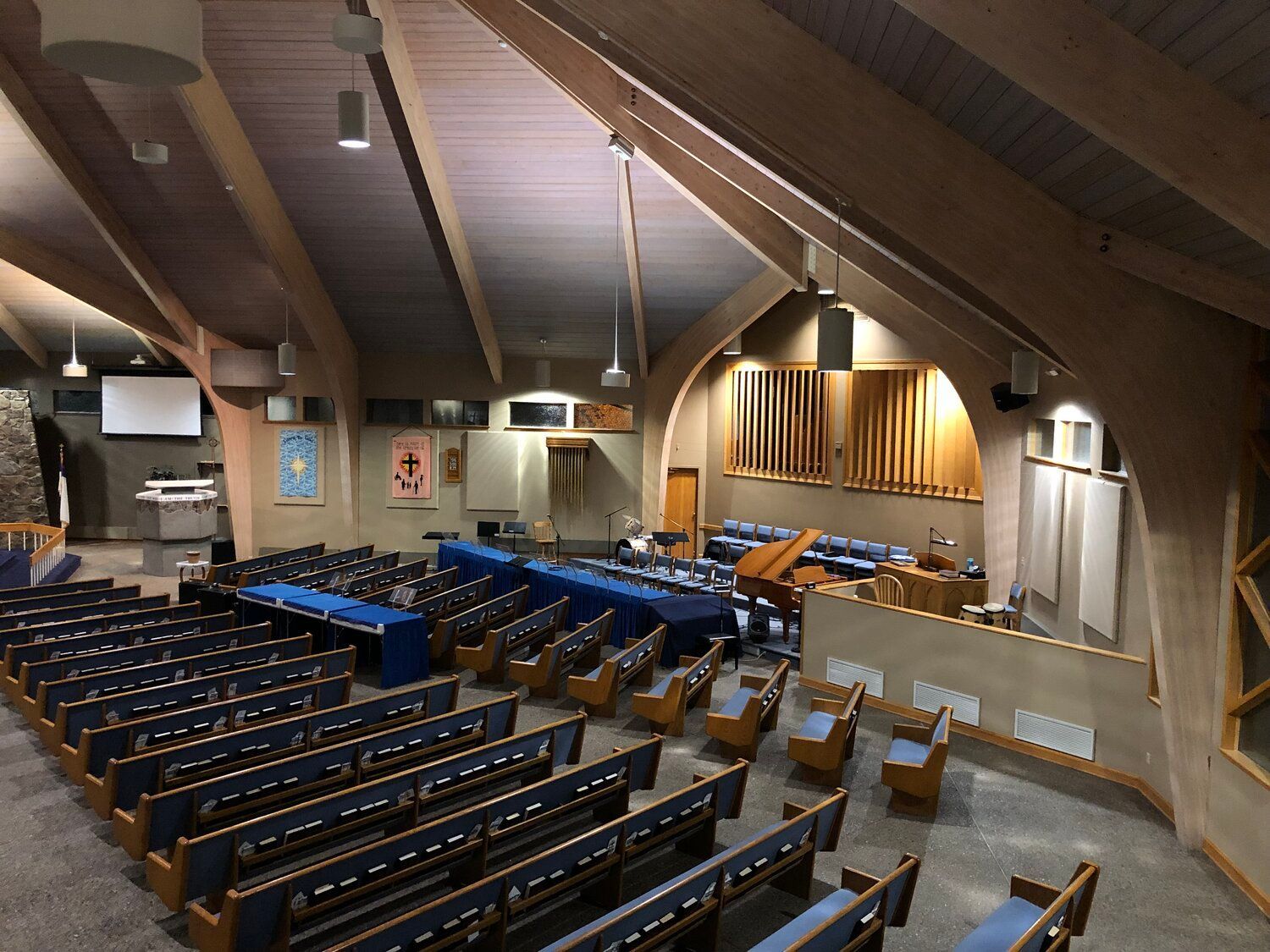 The inside of a church with rows of blue seats
