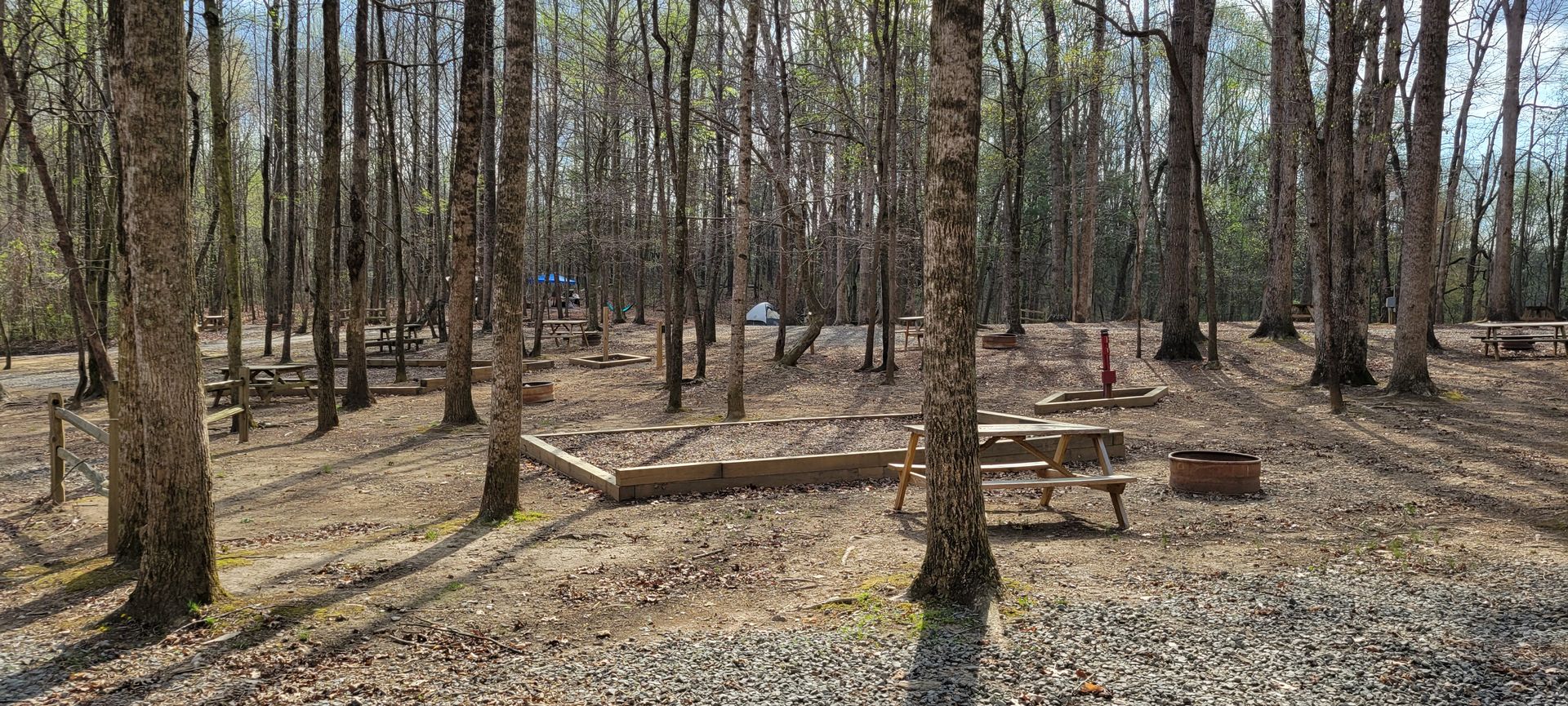 A picnic table is sitting in the middle of a large tent camping area.