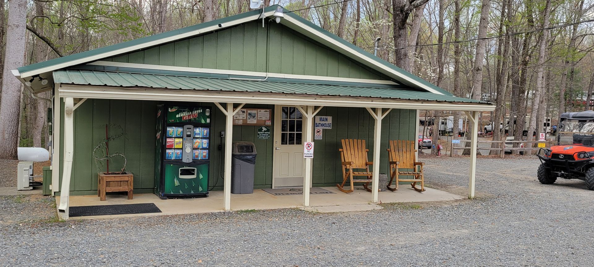 A green building with a green vending machine in front of it