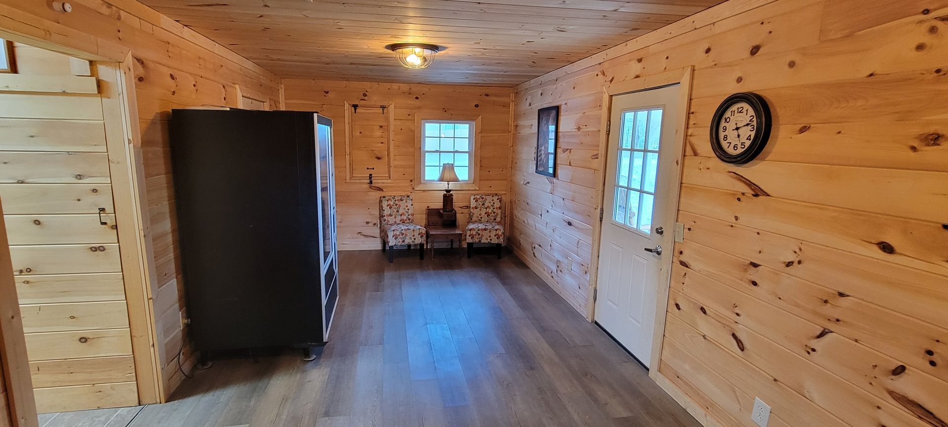 A long wooden hallway with a clock on the wall