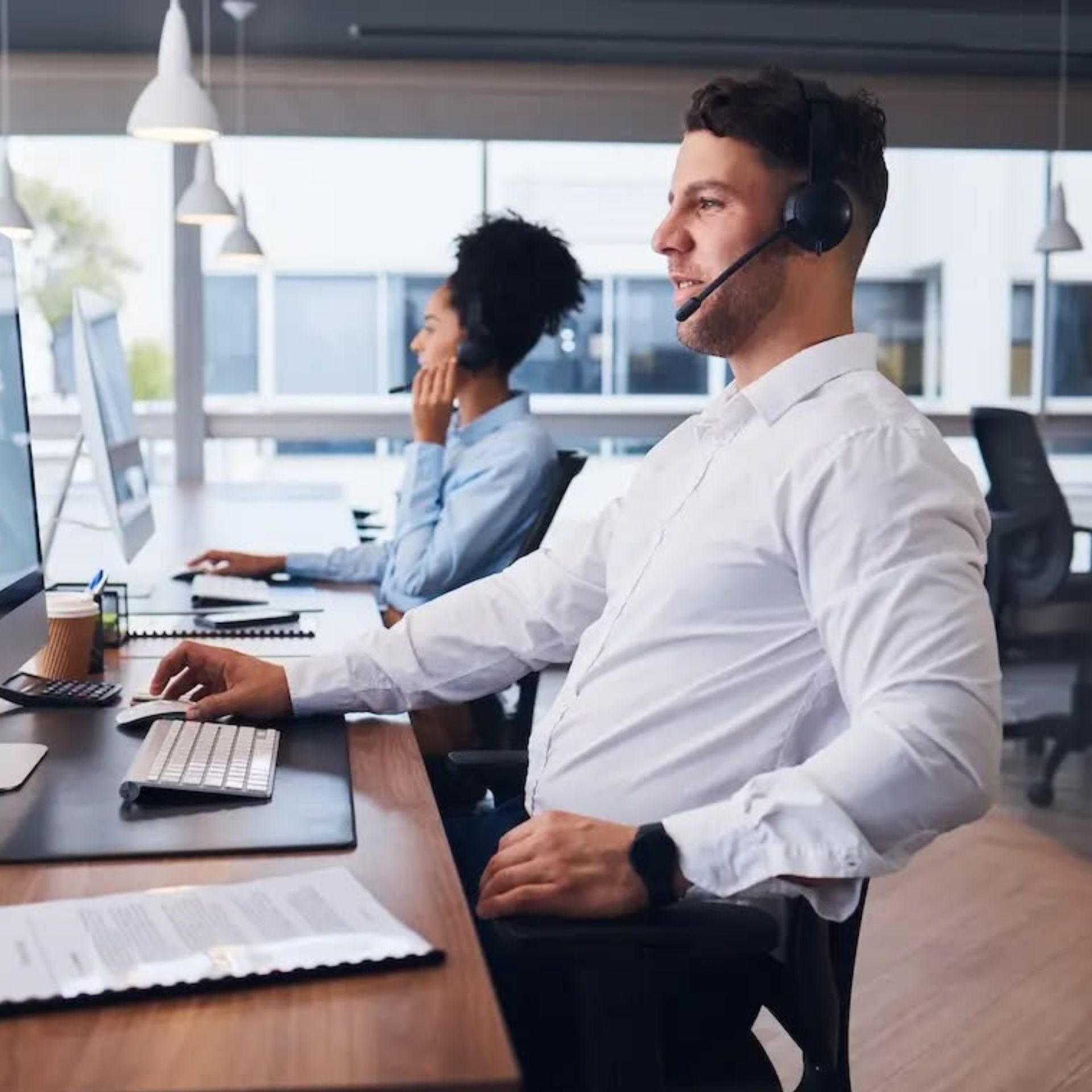 Call center agents working at computers in a modern office