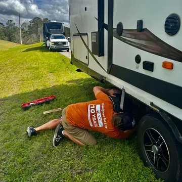 A reflection trailer is parked in a grassy field.