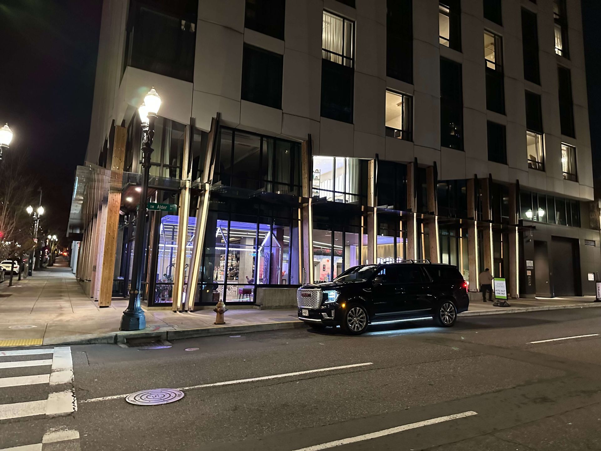 luxury black SUV parked outside Oregon airport terminal