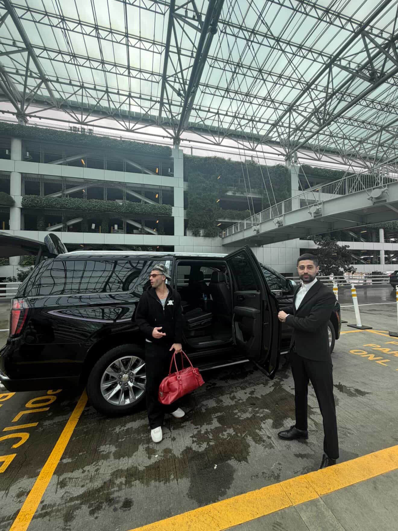 Portland chauffeur opening the rear door of a luxury sedan for a passenger