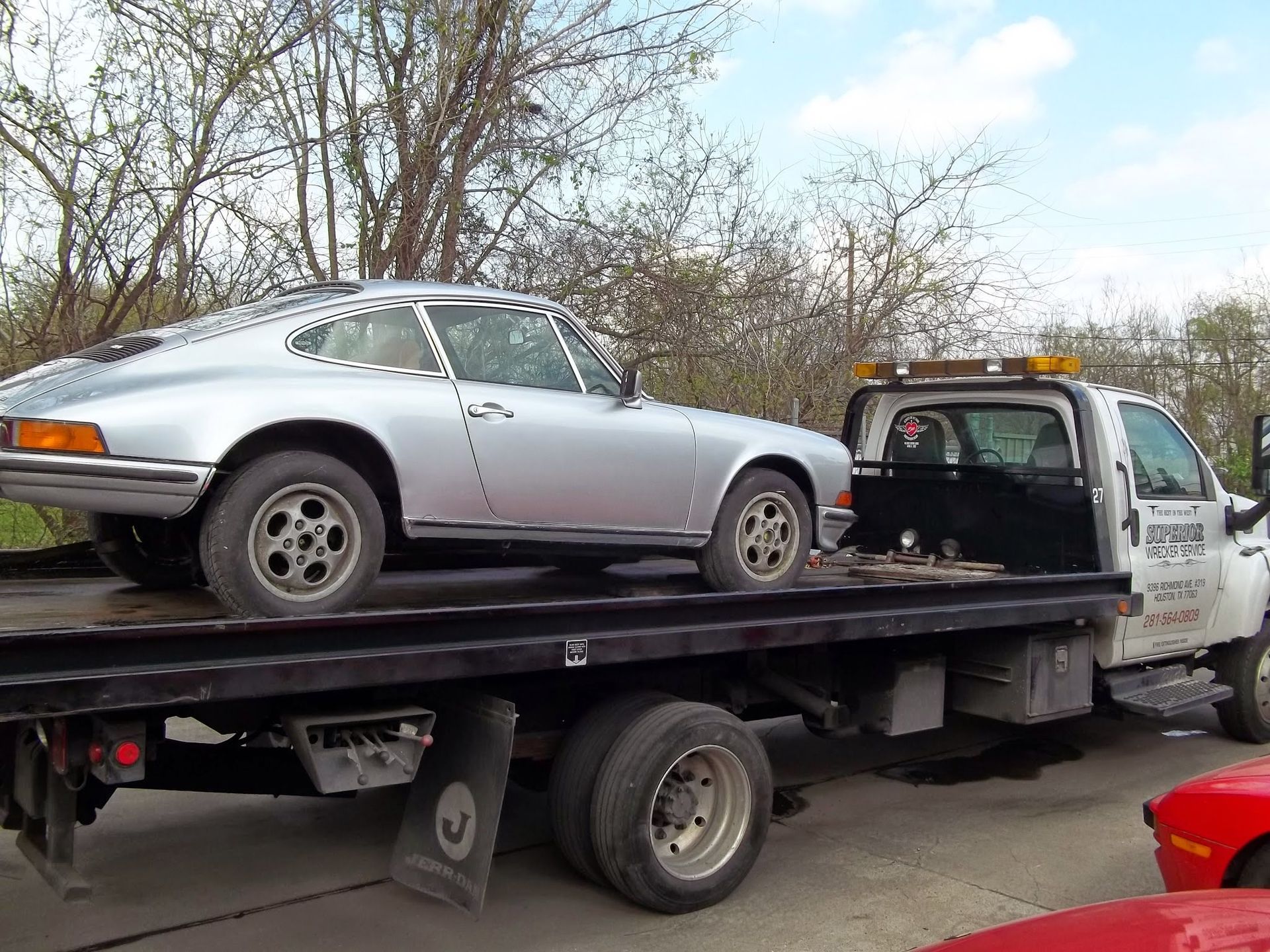 Silver porsche 911 being towed