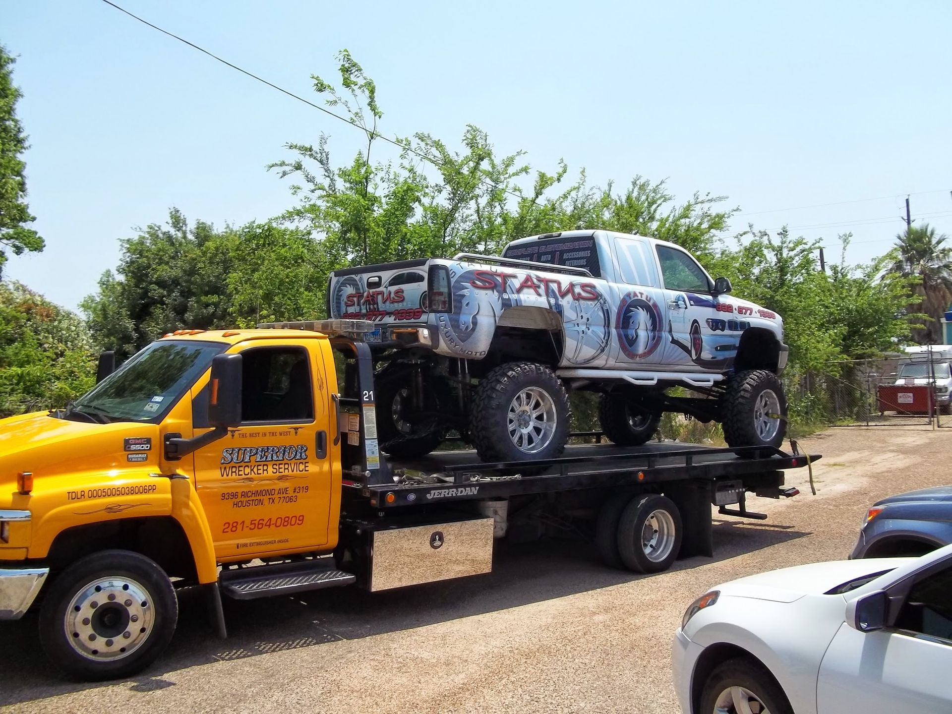 Yellow tow truck carrying a lifted