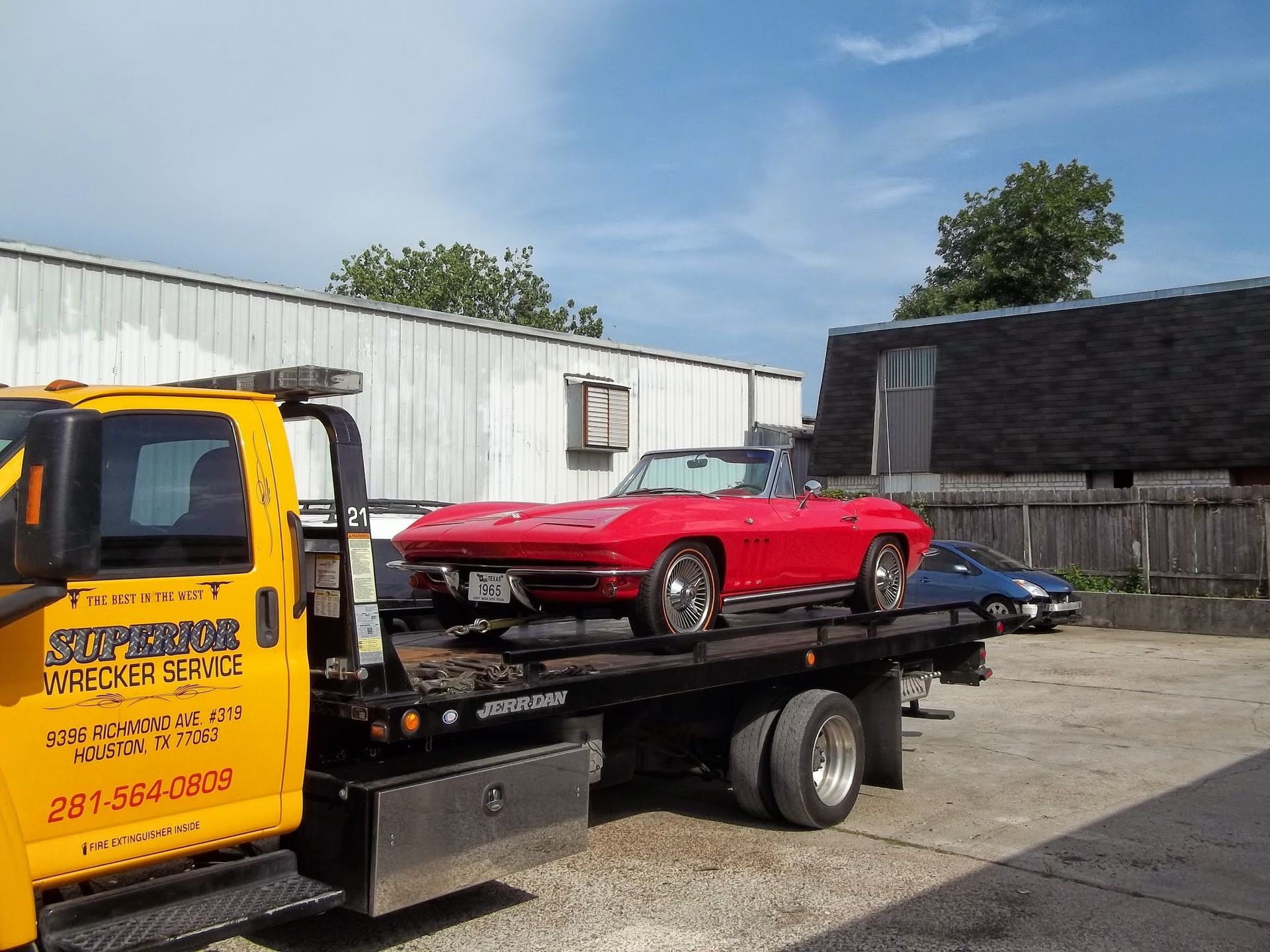 Red convertible car on a yellow tow truck